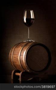 Wineglass with red wine on a wooden barrel
