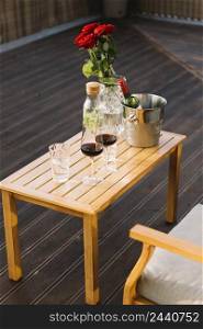 wineglasses ice bucket with wine bottle wooden table patio