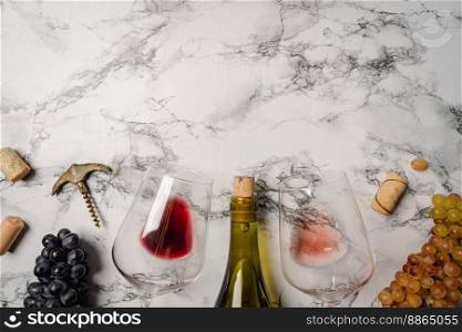 Wineglasses with red wine, fresh grapes and corks on white calacatta background with copy space. Wineglasses with grapes