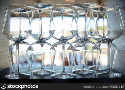winery, glassware and alcohol concept - empty wine glasses set on shelf at restaurant