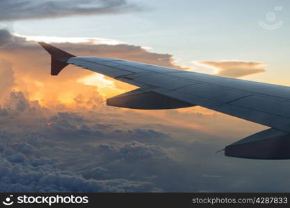 Wing of an airplane flying above the clouds