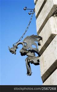 Winged gargoyle chained to wall.
