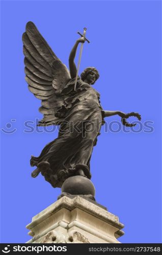 "Winged statue of Victory in Colchester War Memorial. In her right hand she is holding a sword, point downwards so that it represents "The Cross of Sacrifice" and "The Sword of Devotion," and in her left a wreath of laurel. "