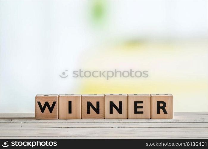 Winner sign made of cubes on a wooden desk