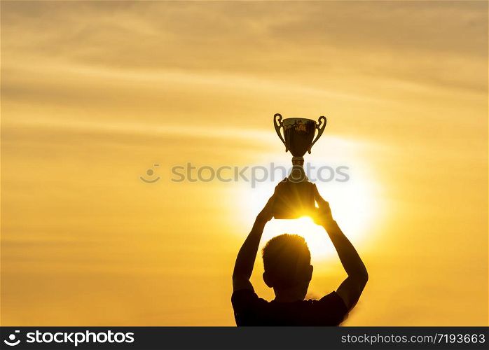 Winner win holding golden champion trophy cup prize. Silhouette best award victory trophy for professional champion challenge team holding gold sport trophy cup over head. Win-Win sport team concept