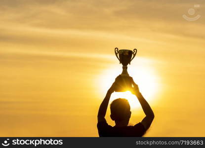 Winner win holding golden champion trophy cup prize. Silhouette best award victory trophy for professional champion challenge team holding gold sport trophy cup over head. Win-Win sport team concept