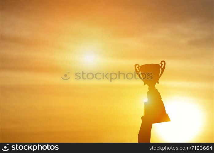 Winner win trophy prize champion concept. Best sport team win championship competition award cup for professional champion challenge. Silhouette hands holding golden trophy cup over head success goal.