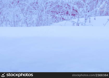 Winter abstract blurred background. Winter garden background with snow-drifts. Winter garden landscape with snowdrifts