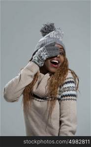 Winter african girl, young beautiful smiling and closing eyes with hands on gray background