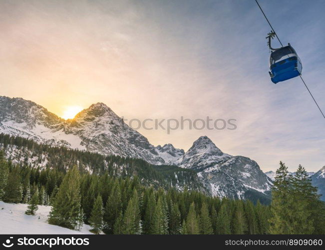 Winter afternoon in the mountains - Winter landscape with evergreen fir forests, the Austrian Alps mountains and a cable car, in Ehrwald municipality, Austria.