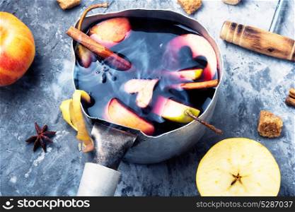 winter alcohol drink. pot with red mulled wine with apple and spices
