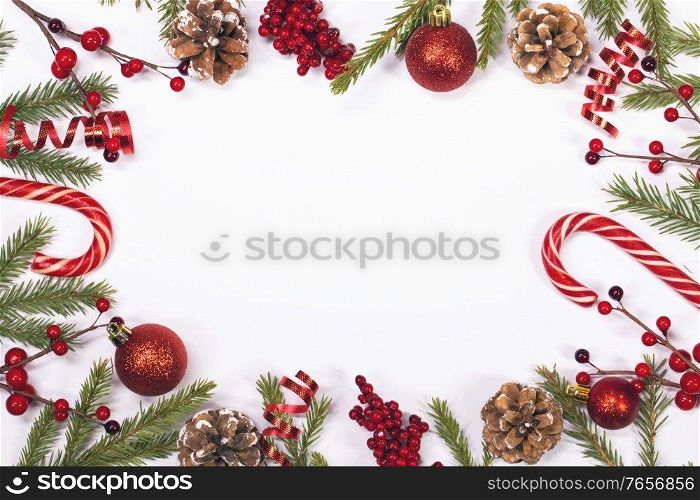 Winter and Christmas frame composition with blank white background, fir tree branch holly berries and pine cones isolated with copy space. Christmas background with decoration