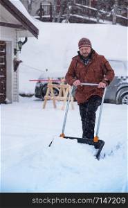 winter and snowfall. man cleans snow with a shovel