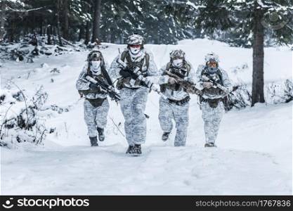 Winter arctic mountains warfare. Action in cold conditions. Squad of soldiers with weapons in forest somewhere above the Arctic Circle. Squad of soldiers in winter forest