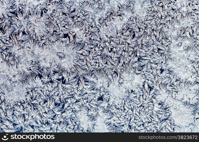 winter background - snowflakes and frost on frozen glass