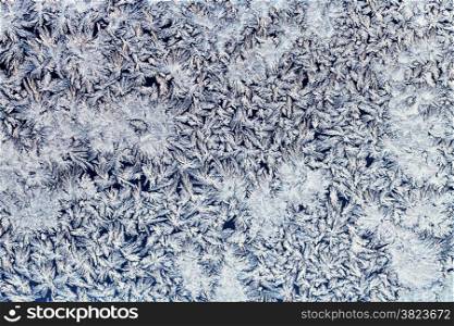 winter background - snowflakes and frost on frozen glass
