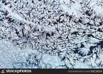 winter background - snowflakes and frost on frozen window