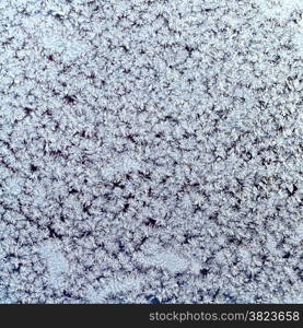 winter background - snowflakes and frost on frozen window glass