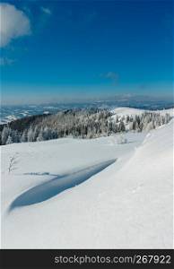 Winter calm mountain landscape with beautiful frosting trees and snowdrifts on slope (Carpathian Mountains, Ukraine). Composite image with considerable depth of field sharpness.