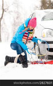 Winter car tire snow chains young woman have problems