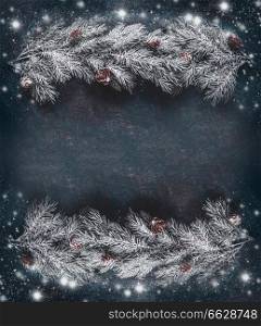 Winter Christmas background frame with hoar and snow covered fir branches with cones, top view with copy space for your greeting text or design