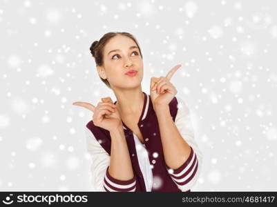 winter, christmas, people and teens concept - happy pretty teenage girl looking up over gray background and snow