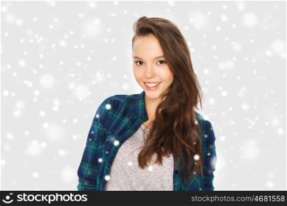 winter, christmas, people and teens concept - happy smiling pretty teenage girl over gray background and snow