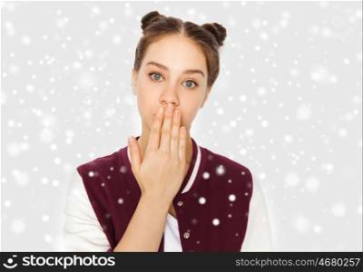 winter, christmas, people, expression and teens concept - confused teenage girl covering her mouth by hand over gray background and snow