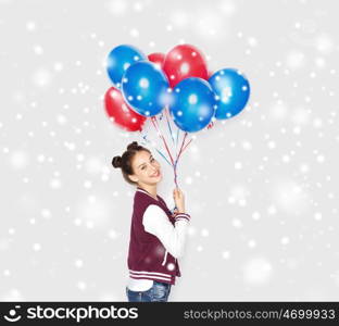 winter, christmas, people, holidays and party concept - happy smiling pretty teenage girl with helium balloons over gray background and snow