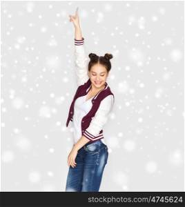 winter, christmas, people, holidays and party concept - happy smiling pretty teenage girl dancing over gray background and snow