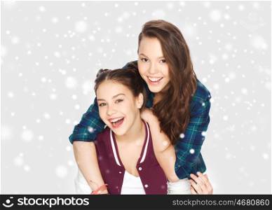 winter, christmas, people, teens and friendship concept - happy smiling pretty teenage girls or friends hugging over gray background and snow