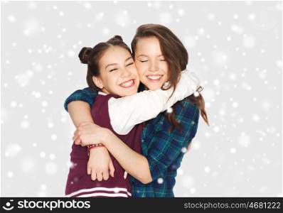 winter, christmas, people, teens and friendship concept - happy smiling pretty teenage girls or friends hugging over gray background and snow