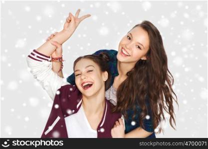 winter, christmas, people, teens and friendship concept - happy smiling pretty teenage girls or friends showing peace hand sign over gray background and snow