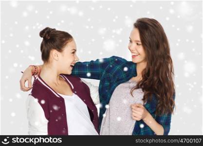 winter, christmas, people, teens and friendship concept - happy smiling pretty teenage girls or friends talking over gray background and snow