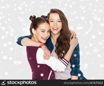 winter, christmas, people, teens and friendship concept - happy smiling pretty teenage girls or friends hugging over gray background and snow