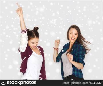 winter, christmas, people, teens and holidays concept - happy smiling pretty teenage girls or friends dancing over gray background and snow