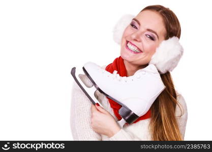 Winter clothing and sport equipment concept. Woman with earmuffs and ice skates. Young lady wearing white outfit.. Woman with earmuffs and ice skates.