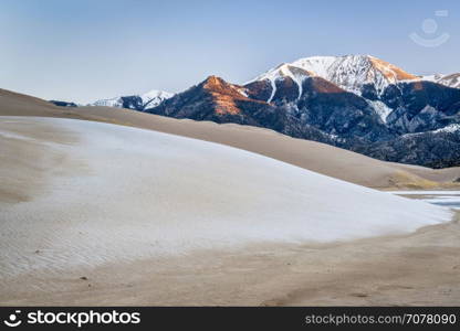 winter dawn over sand dunes covered by frost and first light on Sangre de Cristo Mountains - Great Sand Dunes National Park, Colorado