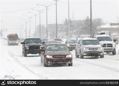 Winter driving. Cars driving on slippery road during heavy snowfall in Toronto