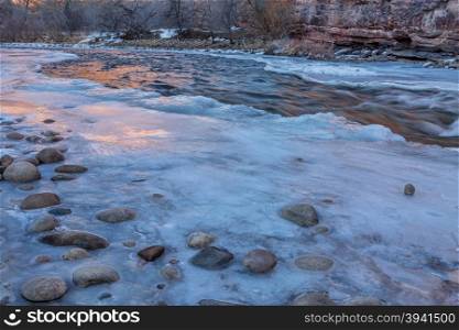 winter dusk over mountain river - partially froze Cache la Poudre River at Belvue near Fort Collins, Colorado