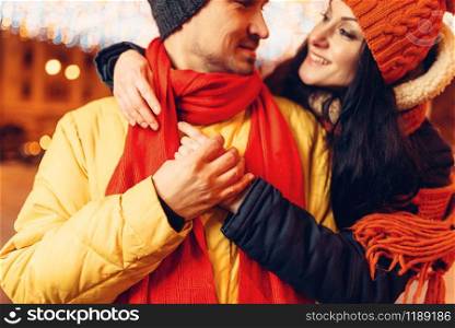 Winter evening, smiling love couple hugs on the street. Man and woman having romantic meeting, happy relationship. Winter evening, smiling love couple hugs on street