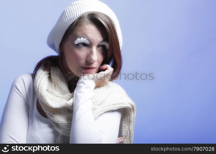 winter fashion beautiful woman in warm clothing stylish creative make up false long white eye lashes blue background