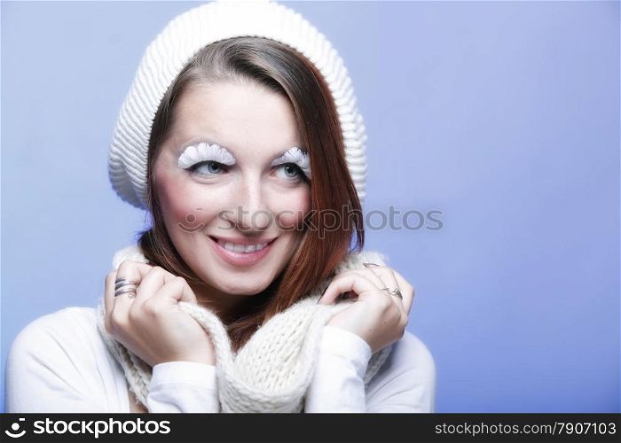 winter fashion beautiful woman in warm clothing stylish creative make up false long white eye lashes blue background