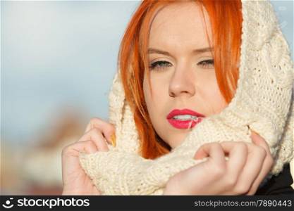 Winter fashion. Beauty face portrait red hair young woman in warm clothing white hood on head outdoor enjoying sunlight on sunny day.