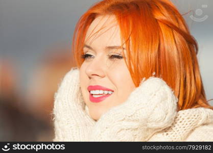 Winter fashion. Beauty face portrait red hair young woman in warm clothing outdoor enjoying sunlight on sunny day.