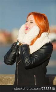 Winter fashion. Beauty girl portrait red hair young woman in warm clothing outdoor enjoying sunlight on sunny day.