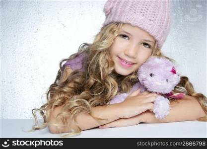 winter fashion cap little girl hug teddy bear smiling silver background