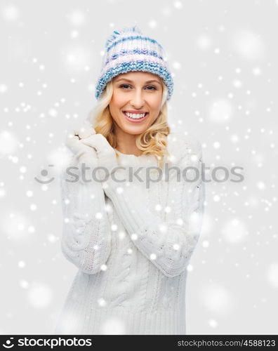 winter, fashion, christmas and people concept - smiling young woman in winter hat, sweater and gloves