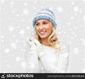 winter, fashion, christmas and people concept - smiling young woman in winter hat, sweater and gloves