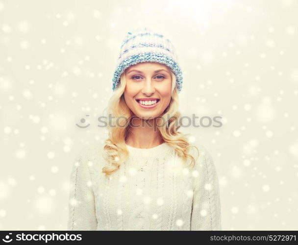 winter, fashion, christmas and people concept - smiling young woman in winter hat, sweater and gloves. smiling young woman in winter hat and sweater